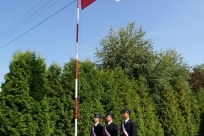 Poczet sztandarowy przy maszcie z flagą państwową